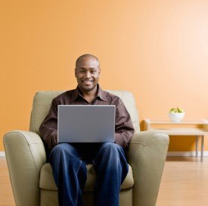 Confident man typing on laptop in livingroom