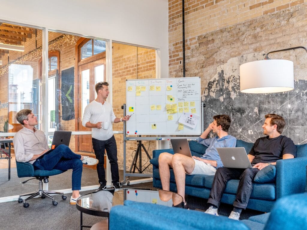 4 guys standing around white board